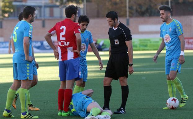 Los jugadores dialogan con el árbitro del partido en Navalcarnero. 