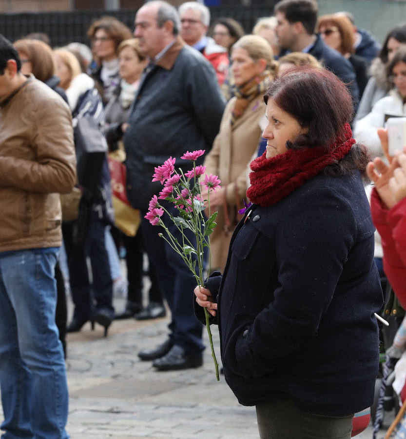 Una mujer entre el público con un ramo de flores moradas. 