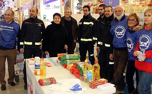 Representantes municipales, bomberos y voluntarios de Banco de Alimentos, en uno de los puntos de recogida instalados este sábado. 