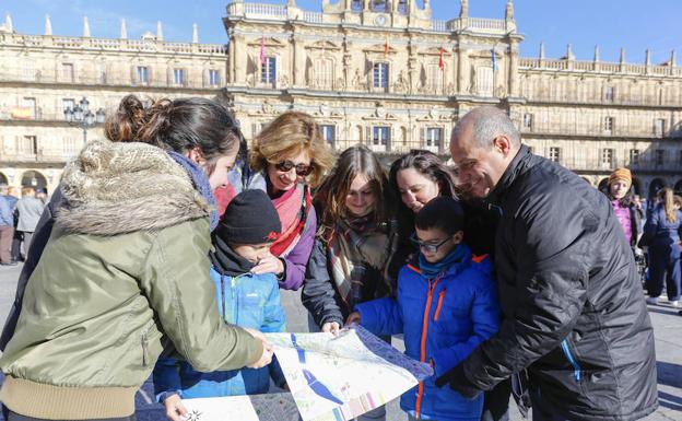 Una familia consulta un mapa de la ciudad en la Plaza Mayor.