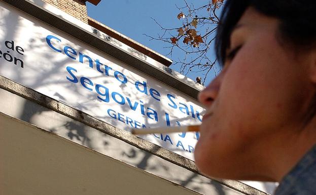 Una joven se enciende un cigarro ante un centro de salud de Segovia