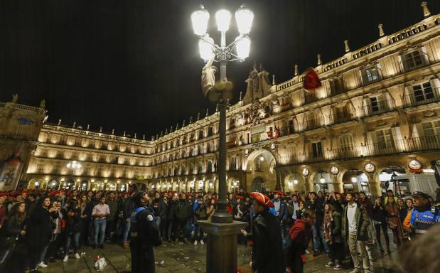 Agentes de la Policía Local observan a un joven encaramado a una farola de la Plaza Mayor, que sería posteriormente denunciado. 