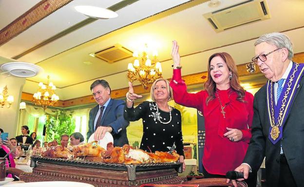 Francisco Vázquez, Paloma Sanz y Silvia Clemente participan el ritual del cochinillo durante el almuerzo navideño. 