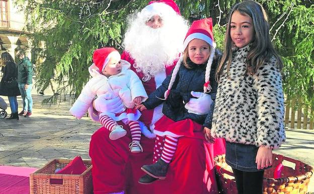 Papá Noel se fotografía con tres niñas en Aguilar 