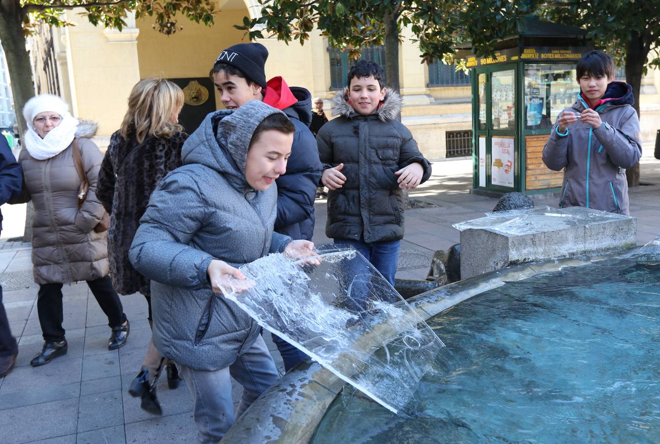 18.01 Unos niños juegan con el hielo en la fuente de la Rinconada.