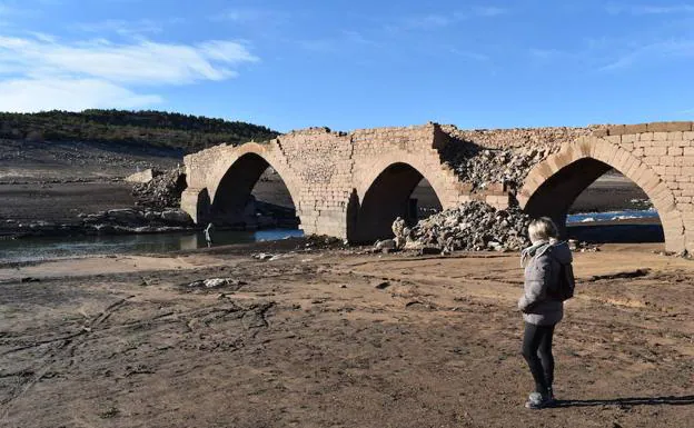 Una mujer observa los restos del puente de Villanueva del Río. 