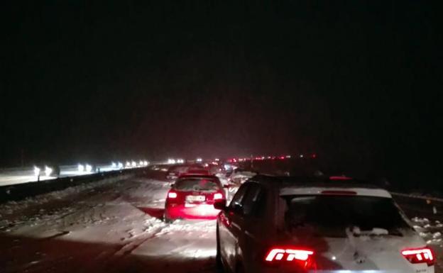 vehiculos, entre la nieve de la AP-6.