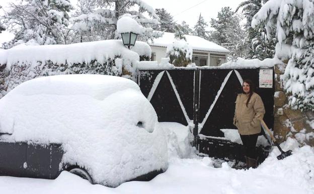 Leticia Puyales, en la puerta de su casa en Marugán, con el coche tapado por la nieve.