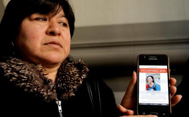 La madre de la joven desaparecida muestra una foto de su hija. 