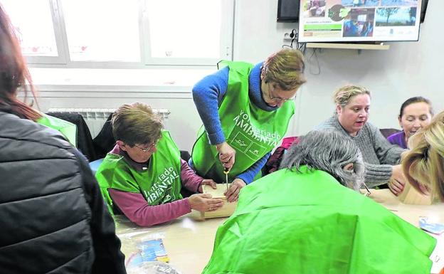 Voluntarios construyen en Olivares de Duero las cajas-nido que colocarán en los árboles.