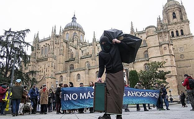 Un activista encarna a una refugiada que arrastra su maleta como símbolo de los inmigrantes que buscan un mundo mejor en Europa. 
