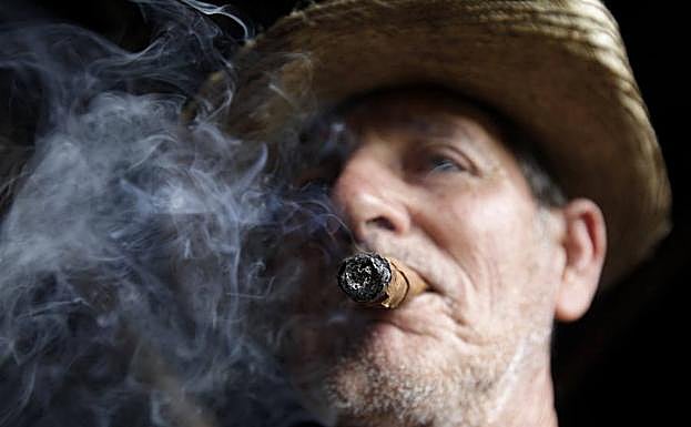 Un hombre fumando un puro. 