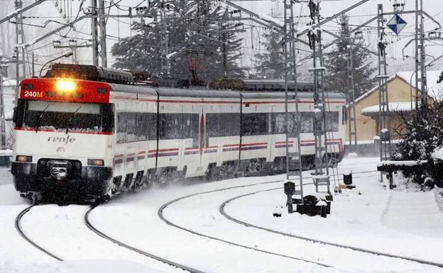 Un tren pasa entre la nieve por unas vías cántabras. 