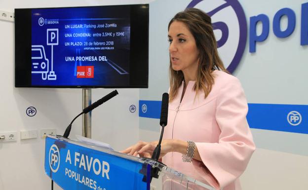 Raquel Fernández, ayer en la sede del PP ante la imagen de la volatina de la campaña. 