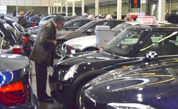 Un hombre observa un vehículo de ocasión en una feria de automoción.