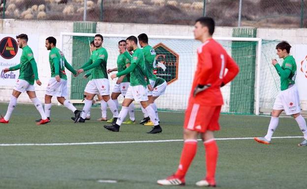 Los jugadores del CDGuijuelo celebran el tanto del empate ante el meta del Real Madrid Castilla. 