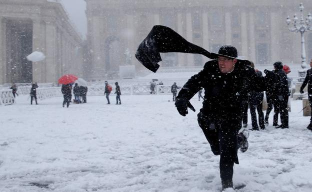Un sacerdote juega con la nieve en la Plaza de San Pedro del Vaticano.