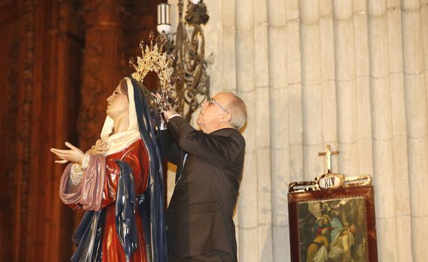 El hermano mayor de la Hermandad del Cristo de la Misericordia coloca la corona a la Virgen del Perdón.