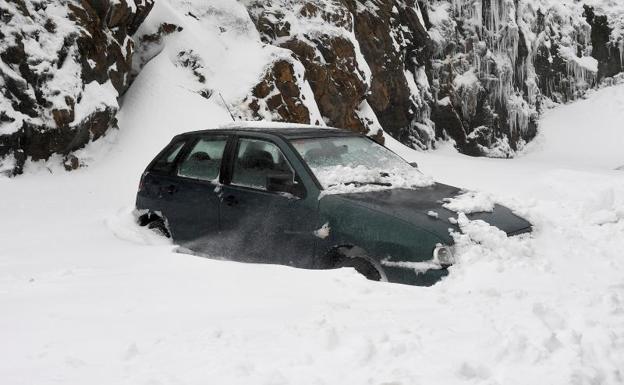 Un vehículo permanece atrapado en la nieve en Busdongo (León). 