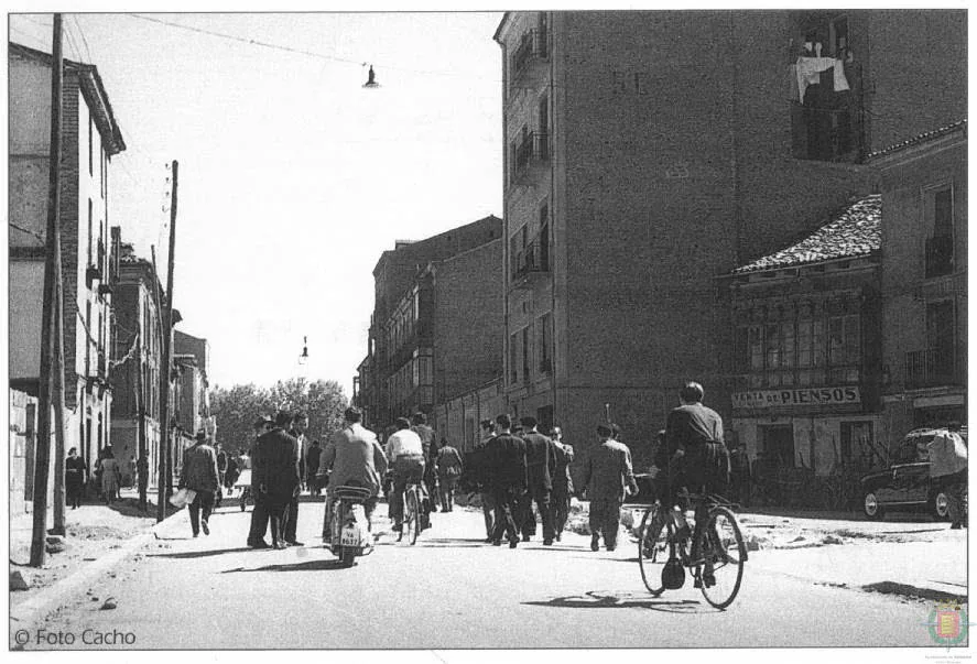 Bicis y viandantes circulan por la calzada de la calle Tudela en Valladolid en los años 60.