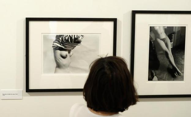 Una mujer observa unos semidesnudos de la exposición. 