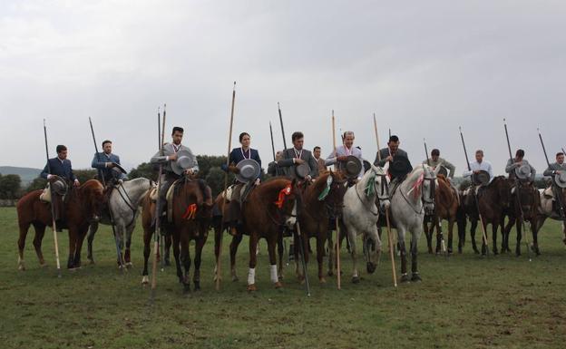 Los participantes, escuchando el himno nacional en sus caballos. 