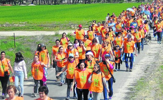 Participantes en la marcha, con sus camisetas de color naranja, durante el recorrido. 