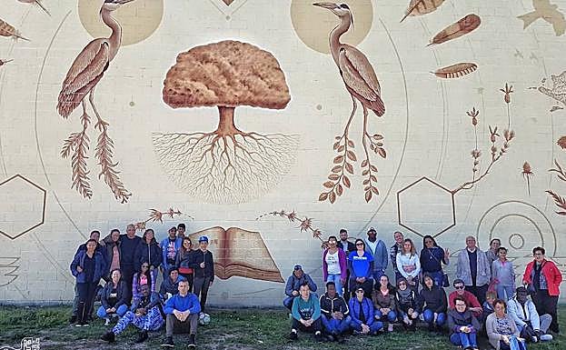 Los visitantes, posan junto al gran mural 'Libro Abierto'. 