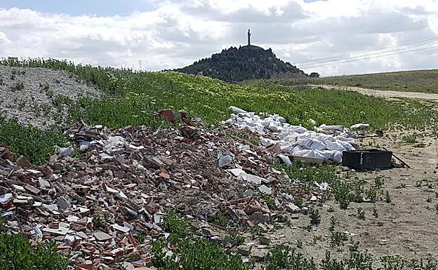 Vertido incontrolado en Palencia, con el Cristo del Otero al fondo. 