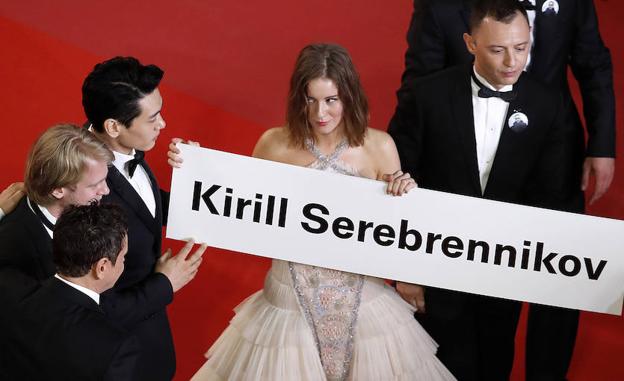 La actriz rusa Irina Starshenbaum (c) y otros miembros del elenco sostienen un cartel con el nombre del director ruso Kirill Serebrennikov. 