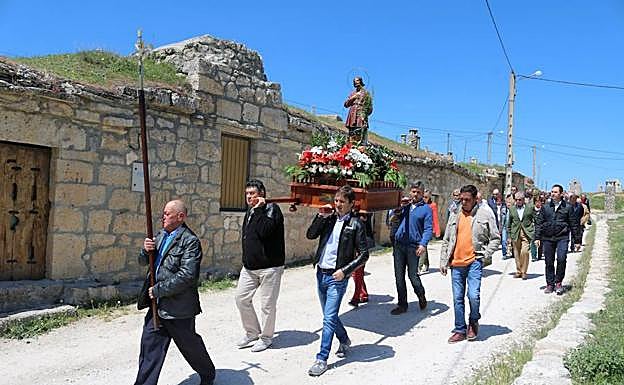 Cuatro vecinos portan en andas la imagen de San Isidro en Baltanás. 