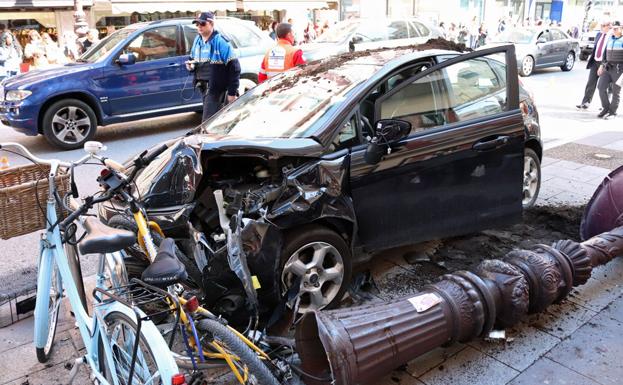 El coche ha quedado destrozado, al igual que una farola derribada y una bicicleta aparcada