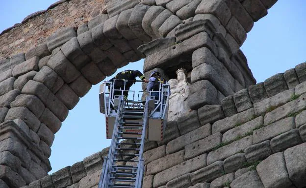Los bomberos examinan la escultura de la Virgen tras el desprendimiento de un fragmento, hace unas semanas. 