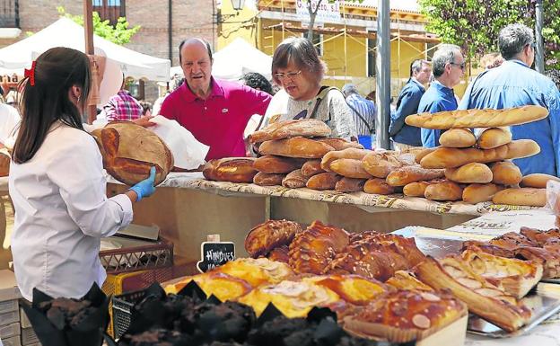 Una panadera de la Tahona de Sahagún atiende a varios clientes. 