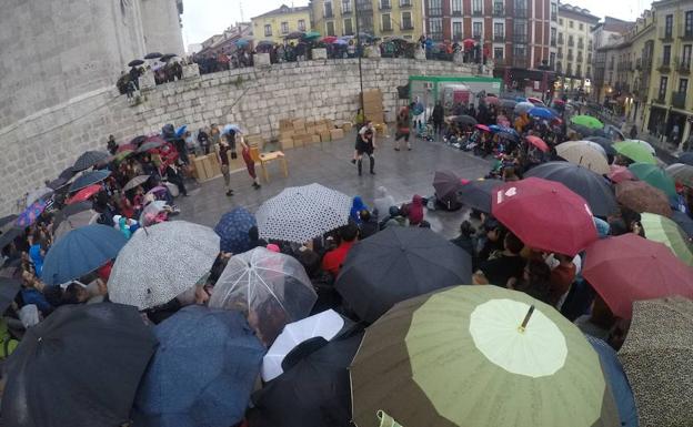 Los paraguas se agolpan en torno al espectáculo de la compañía Faltan 7, en Portugalete. 