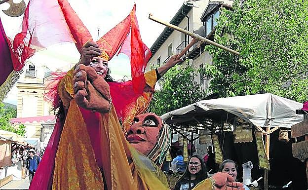 Dos niñas observan a uno de los singulares personajes del mercado. 