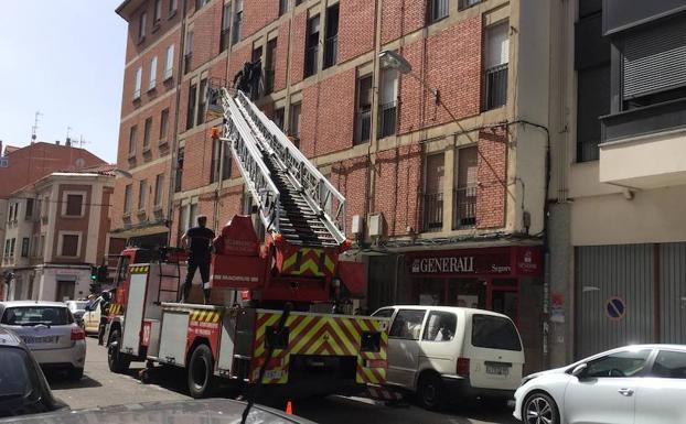 Los bomberos acceden al domicilio por un balcón. 