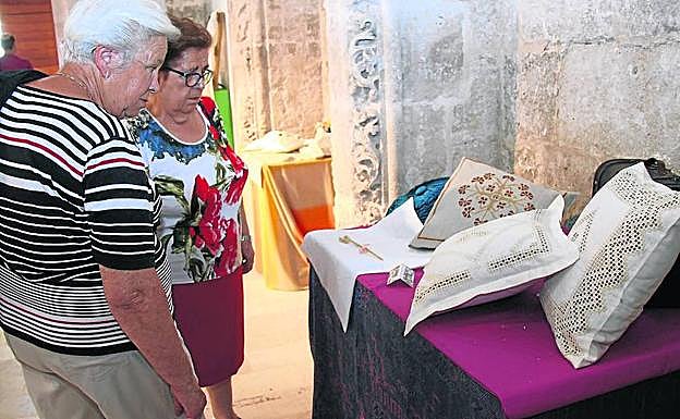 Dos mujeres observan algunos de los trabajos expuestos. 