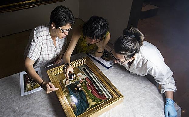 Carmen Espinosa (izquierda), analiza la tabla 'La visitación de la Virgen a Santa Isabel' en compañía de las restauradoras Carolina Gavia y Vanessa Gómez. 