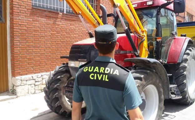 Un guardia civil observa un tractor dañado. 