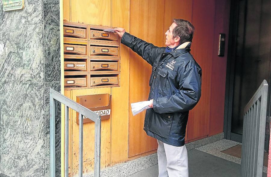 Un usuario de la Fundación Personas introduce en el buzón una de las facturas.