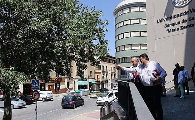 Representantes de la UVA señalan una zona de la acera en el acceso al edificio principal antes de reunirse ayer. 