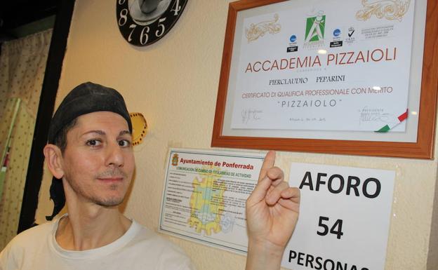 El profesional italiano señala el título que le acredita como maestro pizzero. 