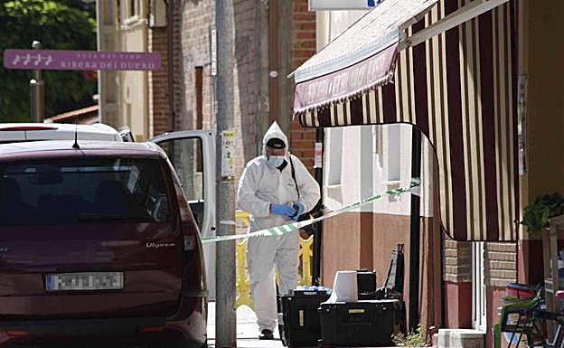 Un agente especial de la UCO descarga los equipos ante la vivienda, precintada y vigilada, justo hace un año.