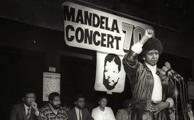 Winnie Mandela levanta su puño durante el anuncio de un concierto en apoyo de Nelson Mandela por su 70 cumpleaños. 