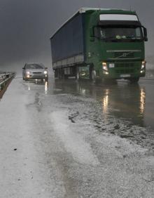 Imagen secundaria 2 - A la izquierda, una tormenta inesperada en Valladolid. Arriba, a la derecha, una tormenta de granizo en la zona de Herrera de Pisuerga que anegó tierras de cultivo. Debajo, la carretera A-67 colapsada por las fuertes lluvias. 