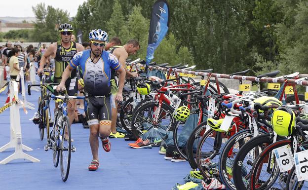 Varios triatletas emprenden el segmento en bicicleta sobre el puente de 25 ojos de Torquemada.