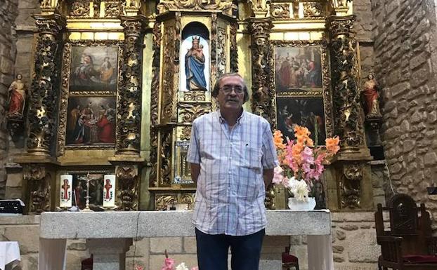 José Bravo delante del retablo de la iglesia de Bogajo.