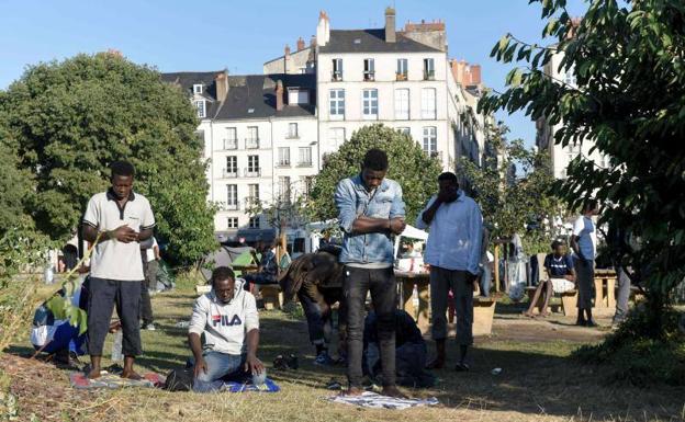 Un grupo de refugiados rezan en Nantes.