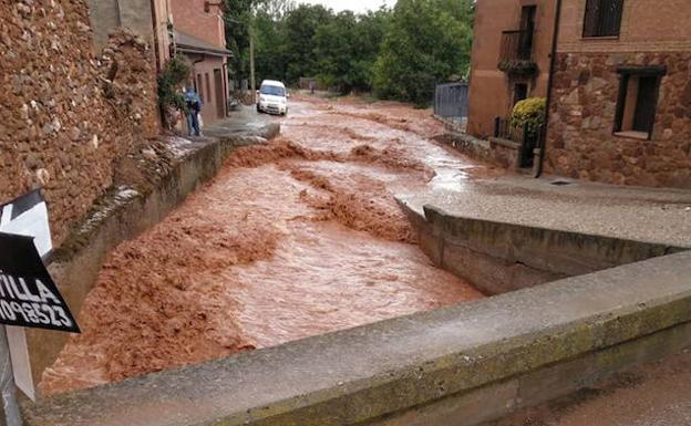 Una calle de Estebanvela anegada por la tormenta del viernes. 
